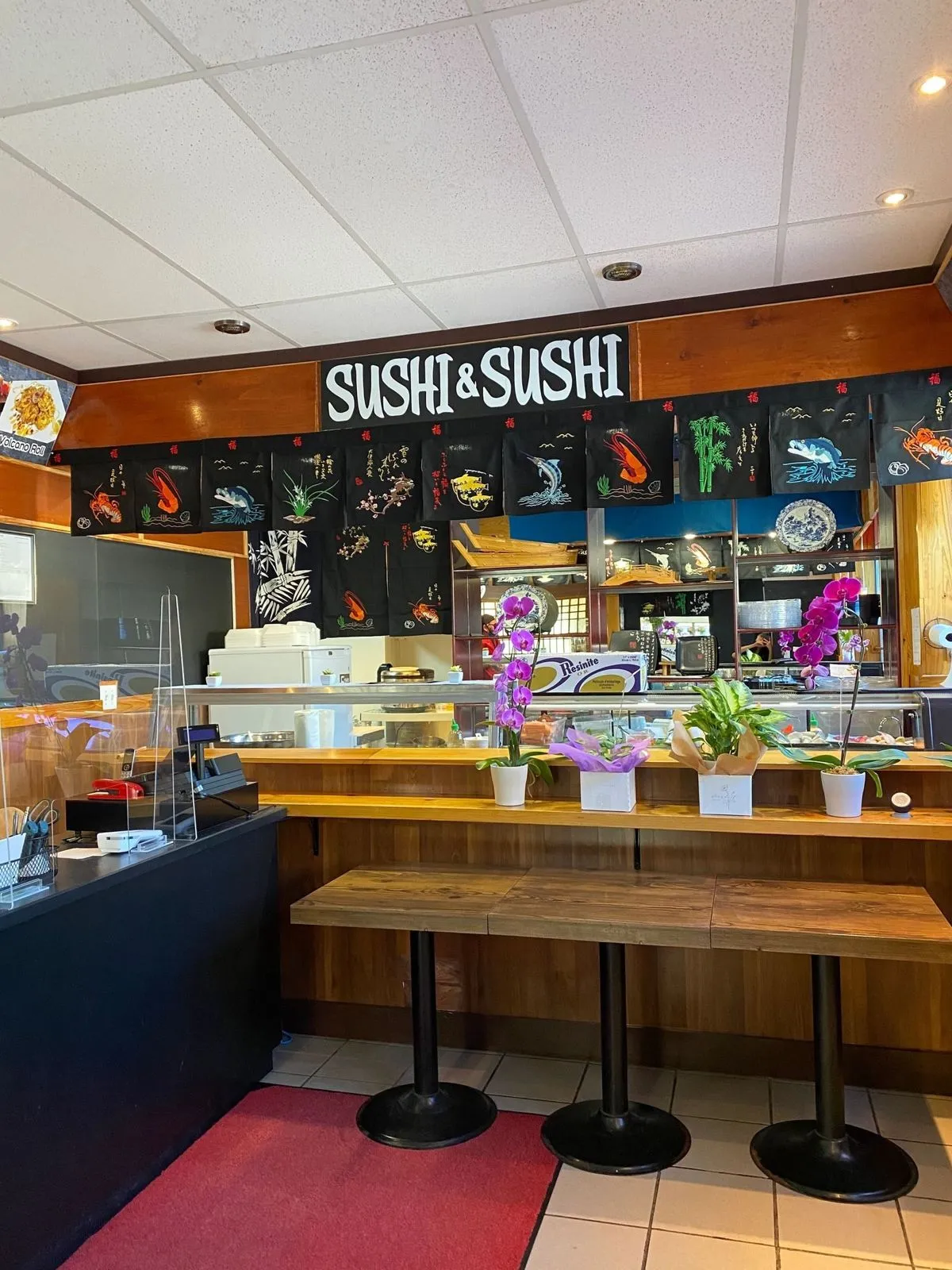 Inside Sushi & Sushi on Eglinton Avenue West, with the sushi bar and signage